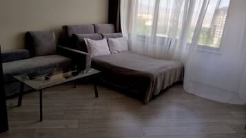 Ein modernes Wohnzimmer mit Sofa, Couchtisch und Bett.