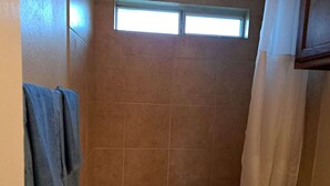Ein Badezimmer mit Badewanne, Fenster und Duschvorhang.