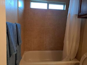 Jetted bath, hair dryer, towels, toilet paper