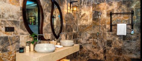A bathroom with two sinks, a large mirror, a towel rack, and a shower.