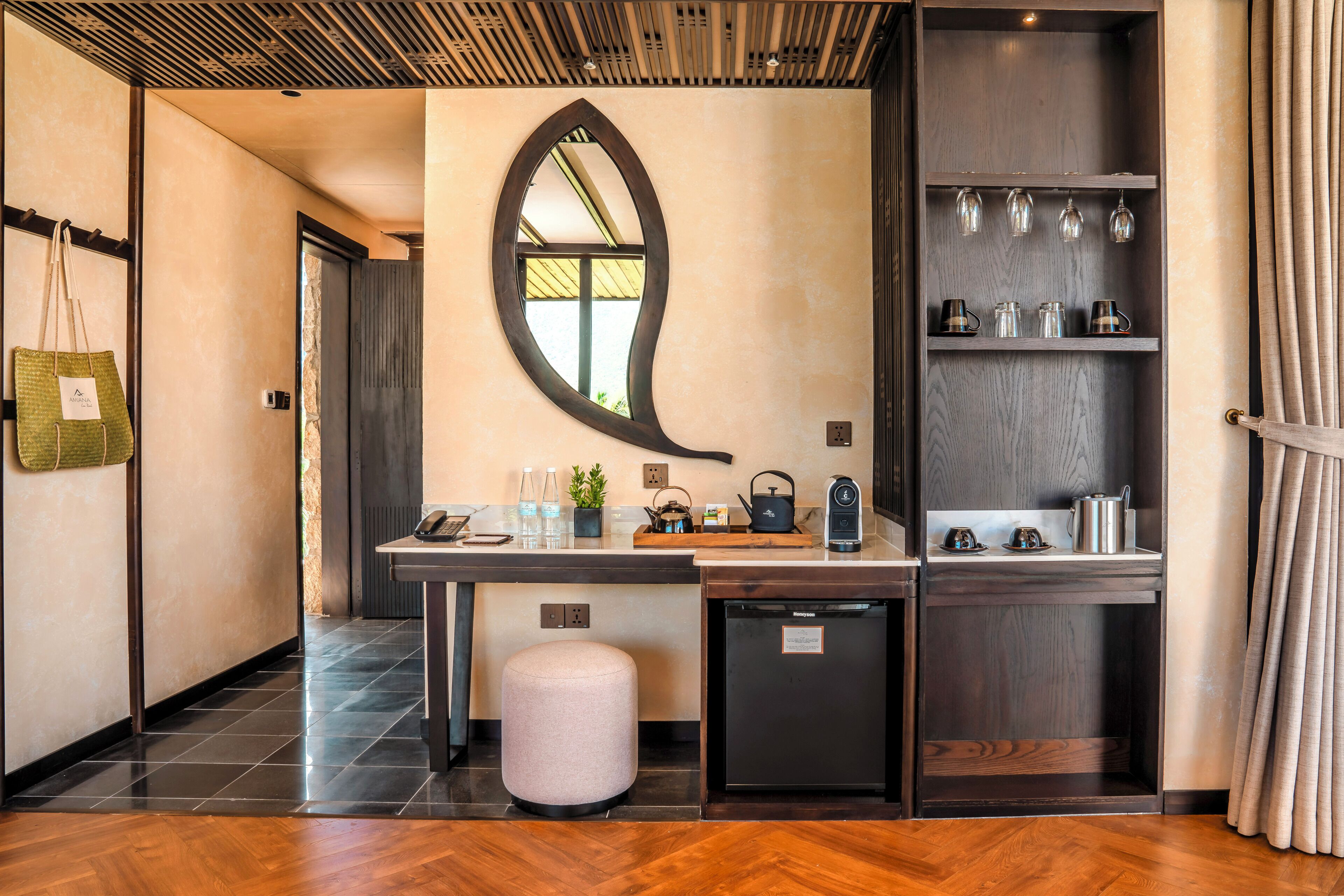 A modern kitchen with a wooden countertop, a small refrigerator, and a mirror above the counter.