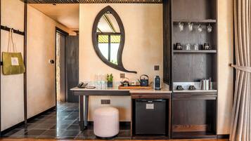 A modern kitchen with a wooden countertop, a small refrigerator, and a mirror above the counter.