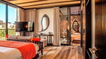 Une chambre d’hôtel moderne dotée d’un grand lit, d’un bureau, d’une télévision et d’une salle de bain avec une porte en verre.