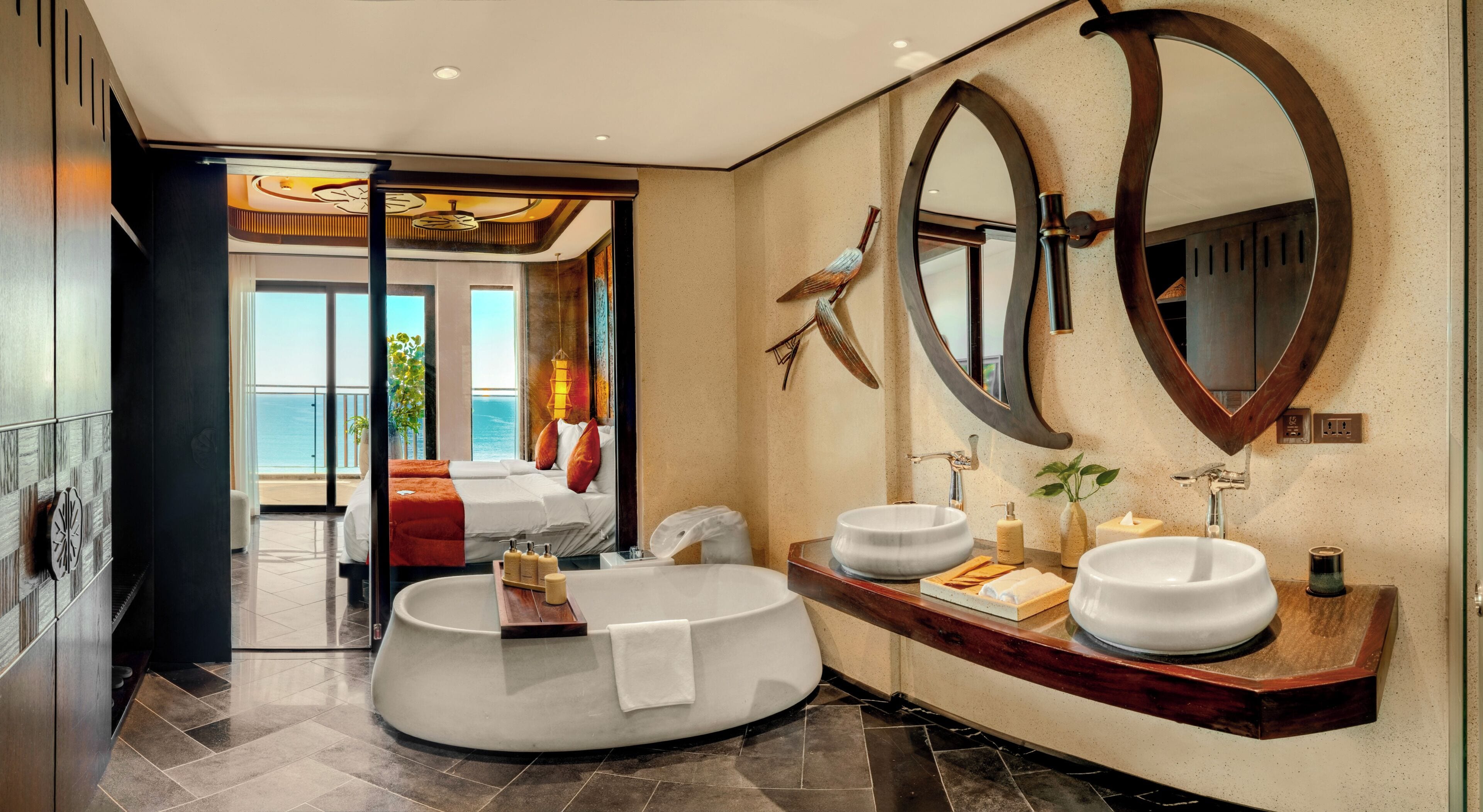 A modern bathroom with a round bathtub, two sinks, and a large mirror.