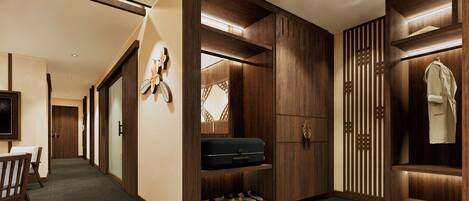A hotel corridor with wooden paneling, a shoe rack, a coat rack, and a television.