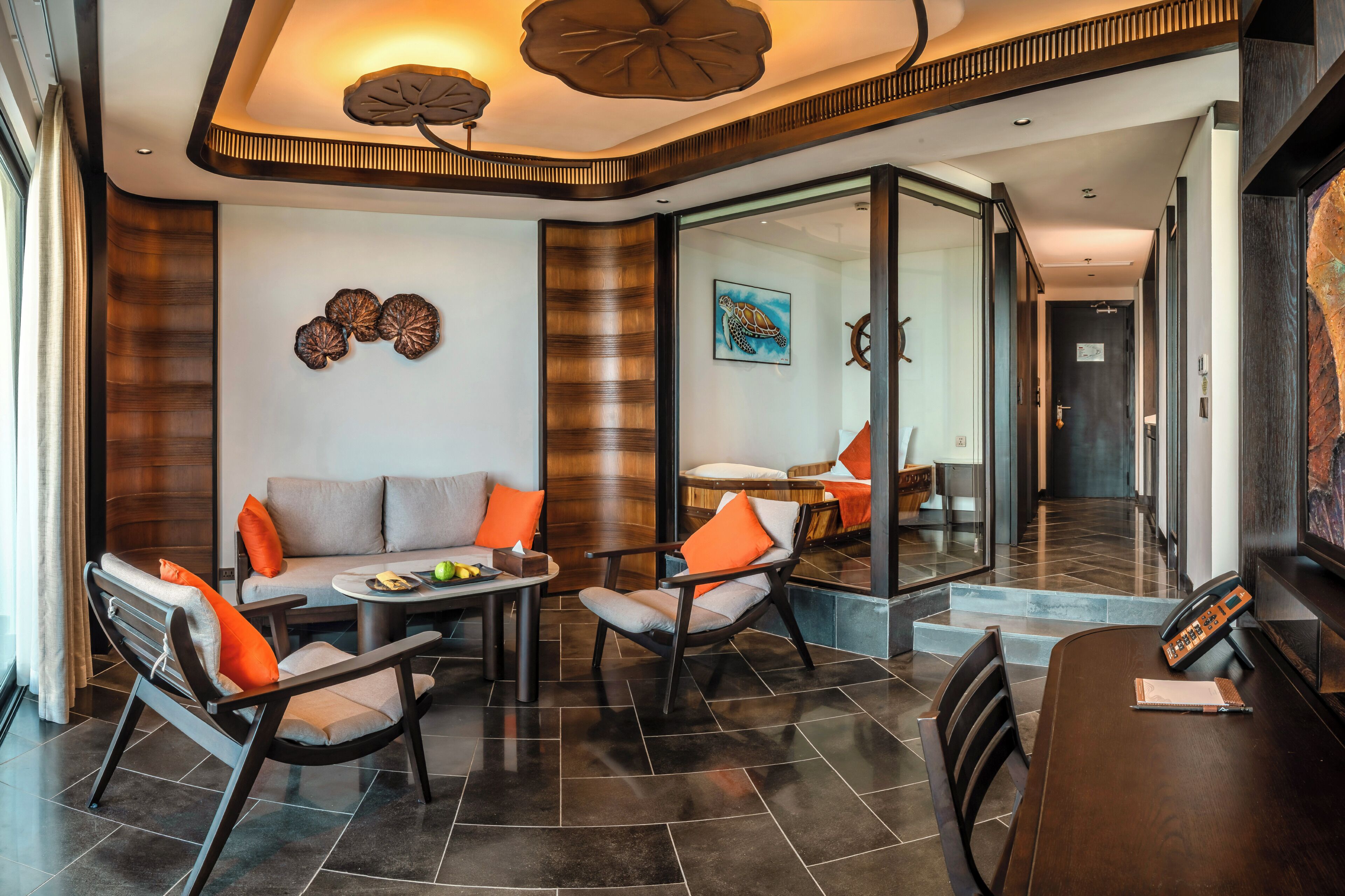 Een moderne hotel lobby met een bank, stoelen, een eettafel en een trap.