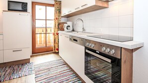 A compact kitchen with a microwave, coffee maker, sink, and oven. - Apartment Plank by Interhome (Kaltenbach)