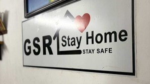 A wall with a sign that reads "GSR Stay Home Stay Safe" and a framed picture above it. - GSR Stay Home (Puducherry)