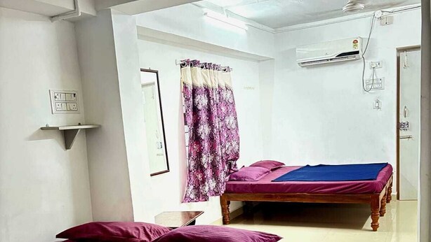 A room with two beds, a sink, and a ceiling fan. - GSR Stay Home (Puducherry)