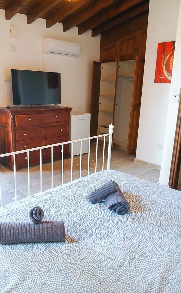A bedroom with a bed, a TV, a dresser, and a wardrobe. - Skarinou Panorama Room (Skarinou)