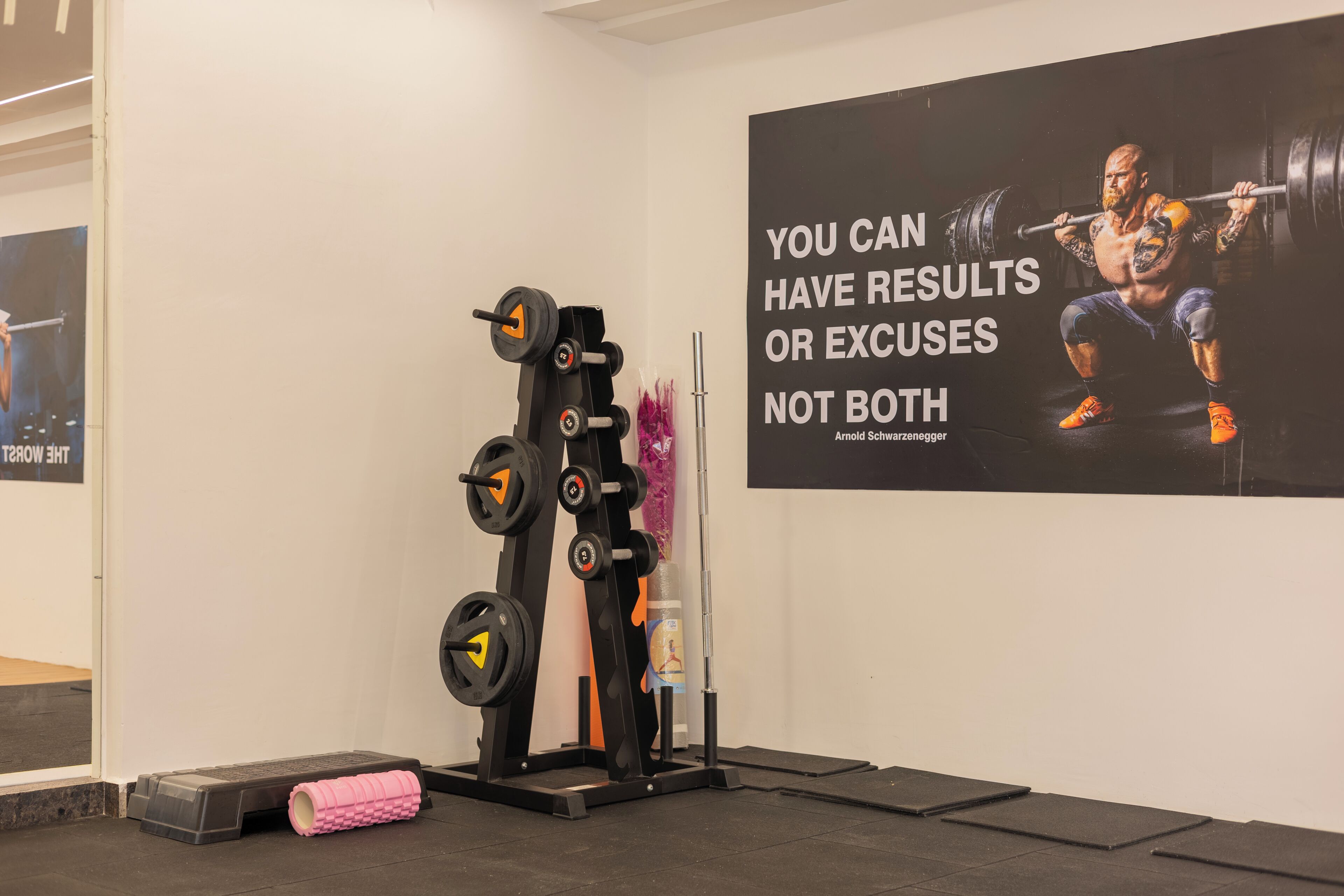 Un gimnasio con una zona de pesas y carteles de motivación en la pared.