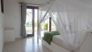 A bedroom with a bed, a curtain, and a view of the outdoors. - Anda Amed Villa and Spa (Karangasem)