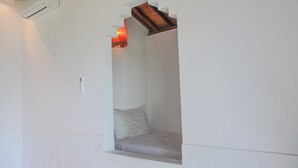 A small, enclosed reading nook with a cushioned bench and a single pillow. - Anda Amed Villa and Spa (Karangasem)
