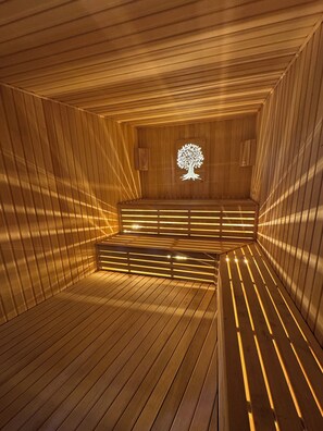 Eine Sauna mit Holzlamellen und einem Baum-Symbol in der Mitte der Wand.