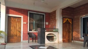 Un área de recepción con puerta de madera, mostrador de recepción y ventanal circular.