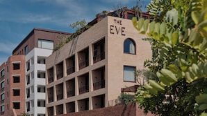 A multi-story building with a sign reading "THE EVE" on the top. - The EVE Hotel Sydney (Redfern)