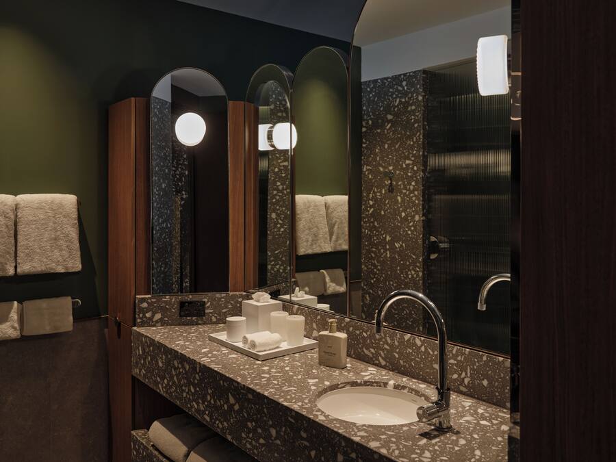 Une salle de bain moderne avec un comptoir en marbre, un grand miroir et un lavabo.