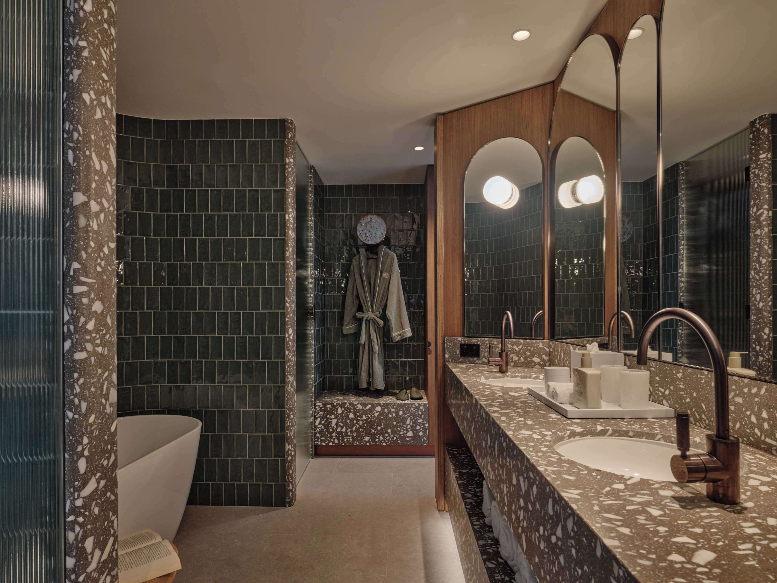 Een moderne badkamer met een grote spiegel, twee wastafels en een bad.