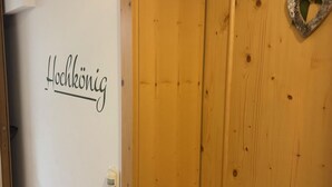 A wooden door with a heart-shaped decoration and a wall with a sign that reads "Hochkönig". - Hochkönig 4 Apartment (Embach)
