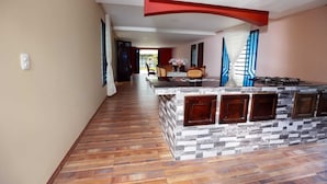 A hallway with a kitchen area featuring a marble backsplash and wooden cabinets.