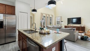 A modern kitchen with granite countertops, stainless steel appliances, and a central island.