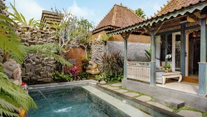 A swimming pool surrounded by tropical plants and a traditional wooden structure. - Astala Ubud Villa (Ubud)