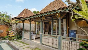 A traditional house with a tiled roof, a stone pathway, and a small pool. - Astala Ubud Villa (Ubud)