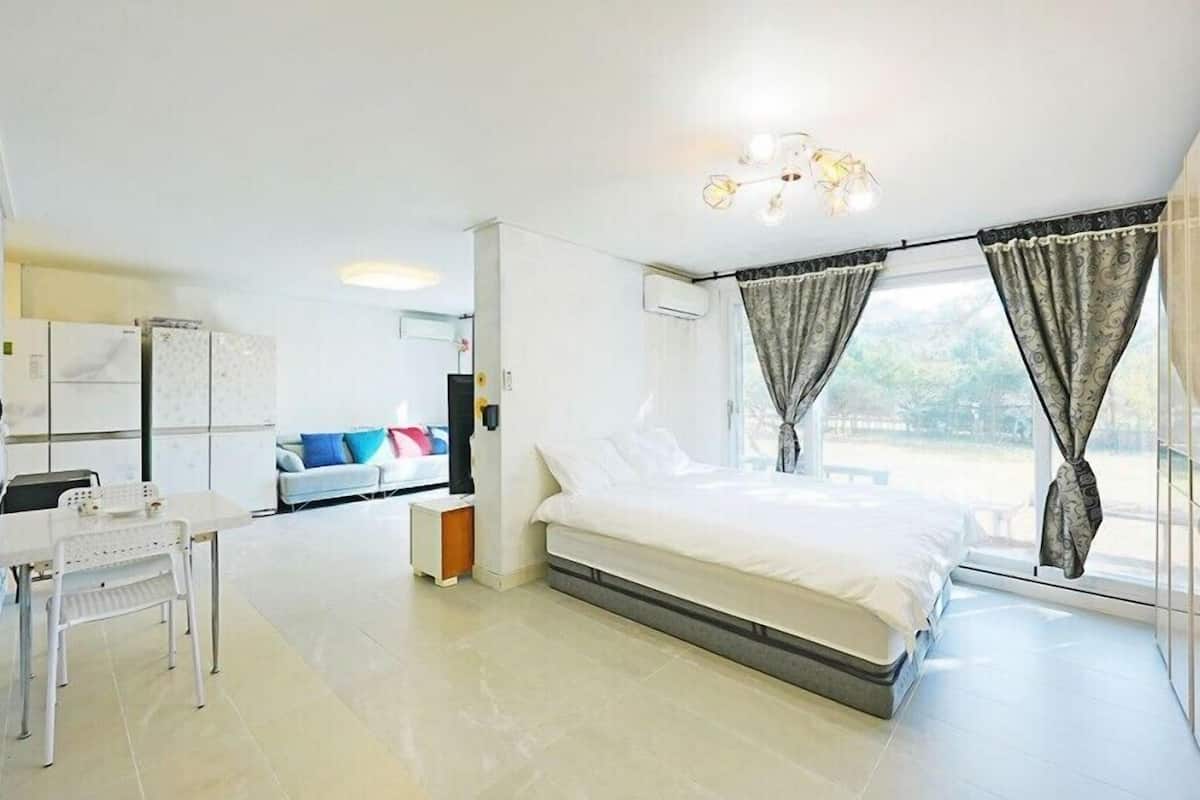 Une chambre à coucher moderne avec un lit, un bureau et un canapé.