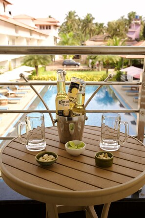 Uma mesa com uma garrafa de Corona Extra, dois copos e uma tigela de azeitonas.