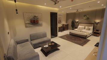A modern living room with a sofa, a coffee table, a bed, and a dining area.