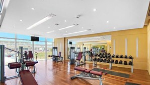 A gym with various exercise equipment, a bench, and a rack of dumbbells. - Bespoke Residences - Tower 108 JVC (Dubai)
