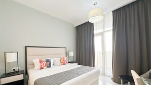 A modern hotel room with a large bed, bedside tables, a chair, and a view of the outdoors. - Bespoke Residences - Tower 108 JVC (Dubai)