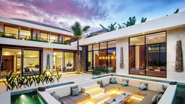Una casa moderna de dos plantas con piscina, mobiliario de exterior y ventanas amplias.