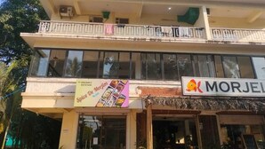 A two-story building with a sign for 'JAS HOLIDAY'S' on the upper floor and 'Spice De Morjim' on the lower floor. - JAS HOLIDAYS MORJIM (Morjim)