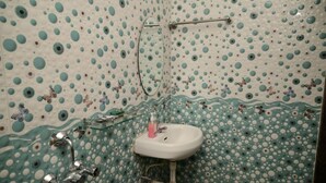 A bathroom with a polka dot tile pattern, a white sink, and chrome fixtures. - JAS HOLIDAYS MORJIM (Morjim)