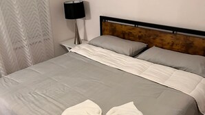A neatly made bed with a bow-shaped pillow on the center. - Charming 1-bedroom apartment in Leander, featuring AC, WiFi (Cedar Park)