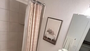 A bathroom with a bathtub, toilet, sink, and a mirror. - Charming 1-bedroom apartment in Leander, featuring AC, WiFi (Cedar Park)