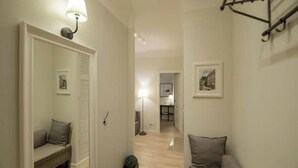 Un couloir avec un banc, une lampe et un tableau encadré au mur.