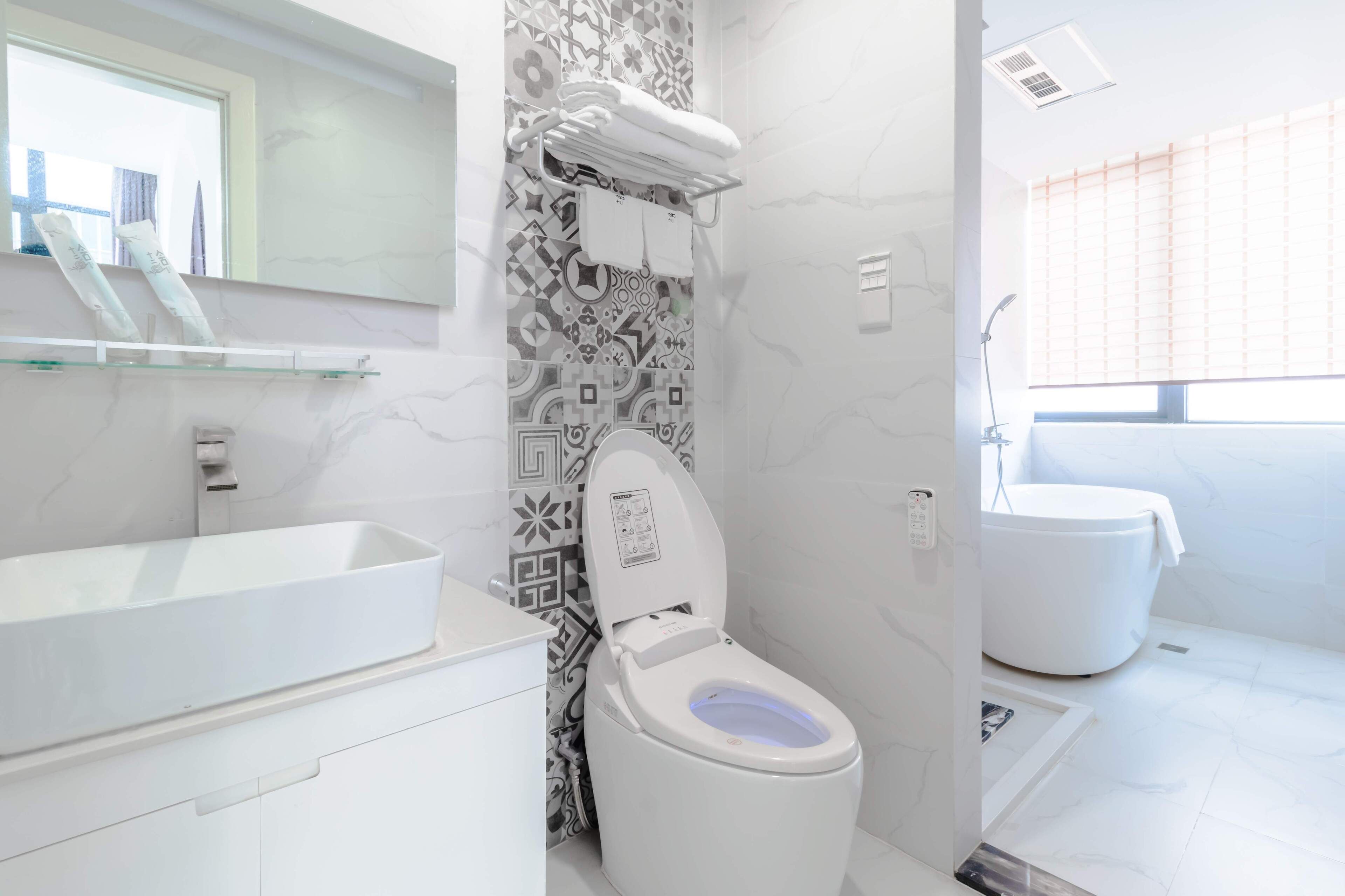 A modern bathroom with a white sink, toilet, and bathtub.