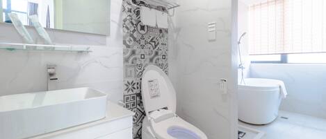 A modern bathroom with a white sink, toilet, and bathtub.