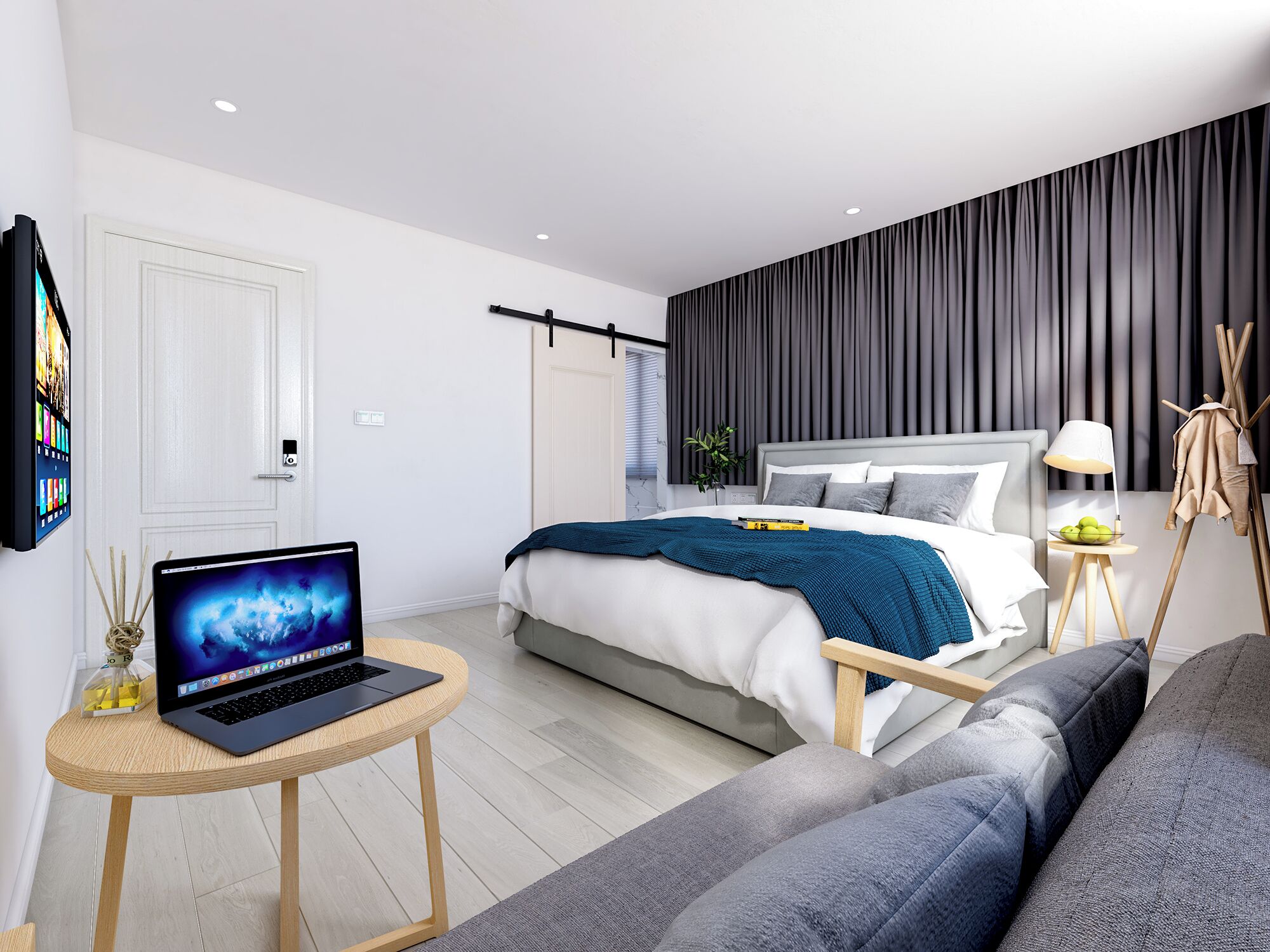 Un dormitorio moderno con una cama, un ordenador portátil sobre una mesita, un sofá y una lámpara de noche.