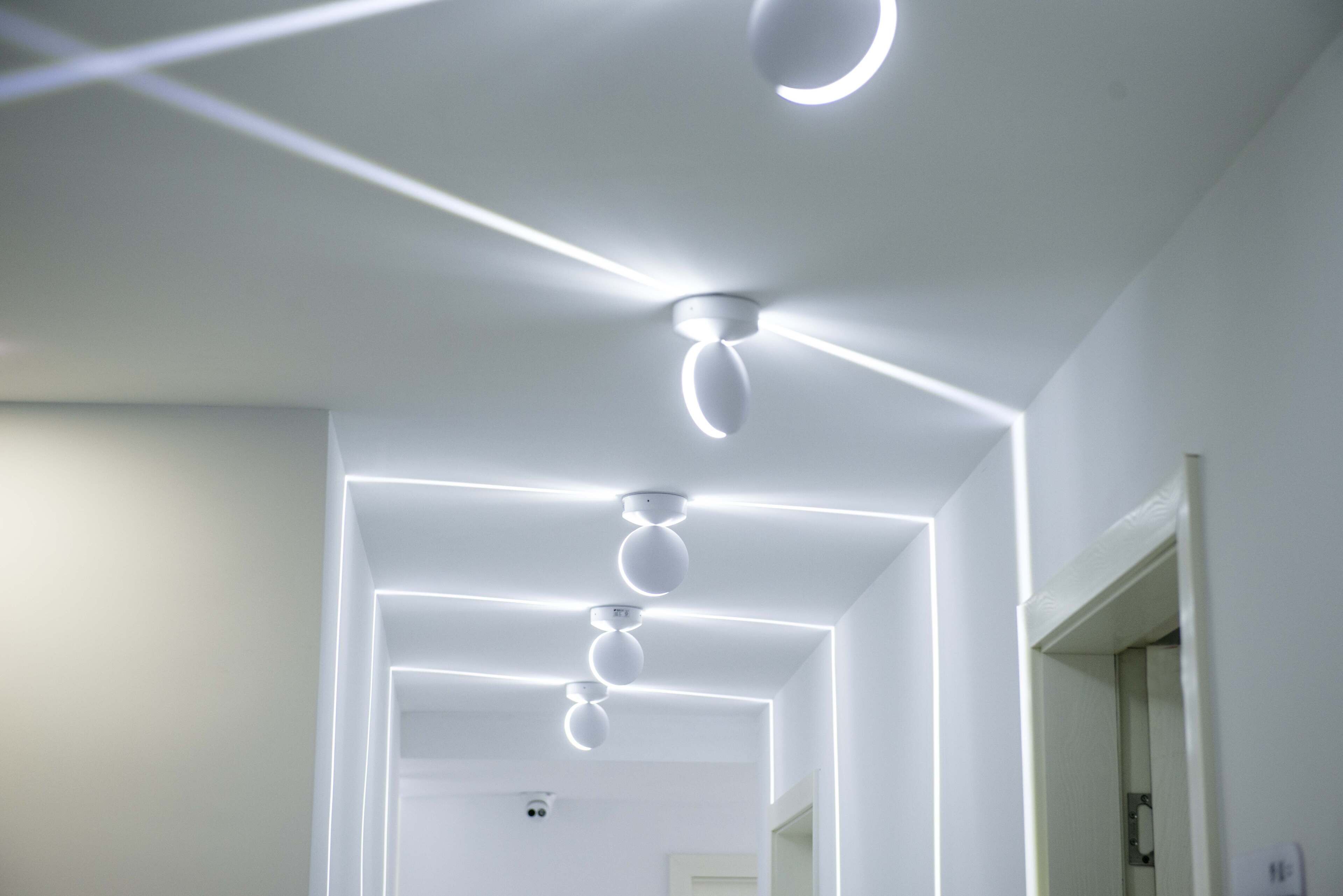 Un techo moderno con iluminación empotrada y un ventilador central.