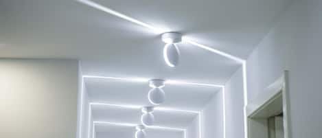 A modern ceiling with recessed lighting and a central fan.