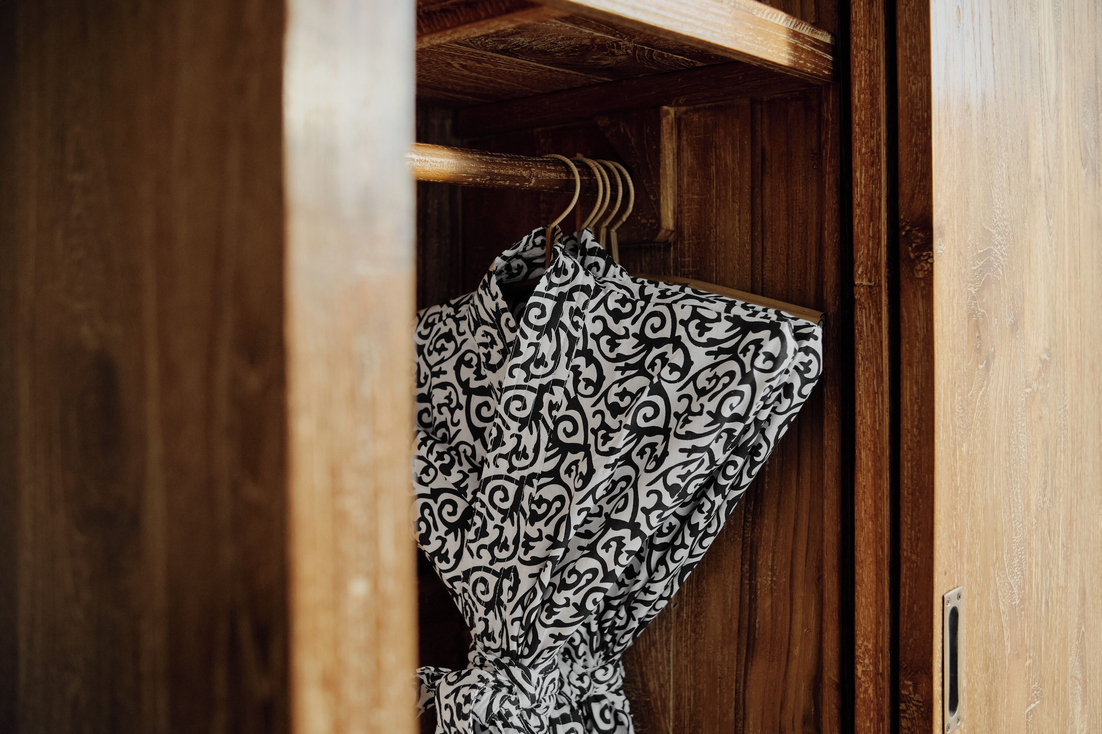 Ein Holzschrank mit Kleiderstange.