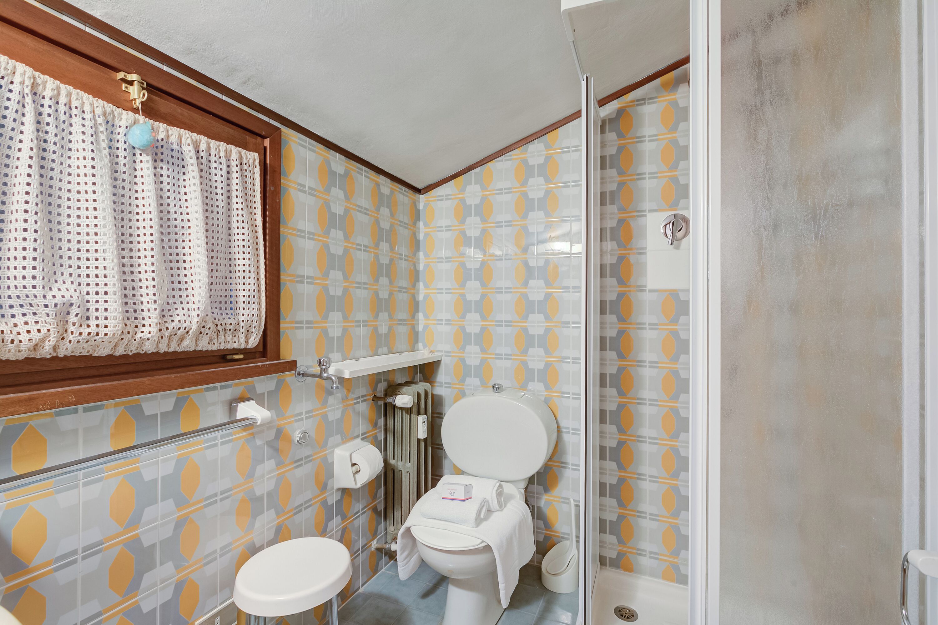 A bathroom with a toilet, bidet, and shower.