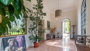 A spacious hallway with a polished floor, a large potted plant, a framed painting, and a bench. - Villa Vallone Luxury With Pool (Galatina)