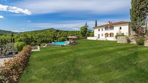A large house with a swimming pool, surrounded by a well-maintained lawn and trees. - Amazing Panoramic Villa La Poggiola (Arezzo)