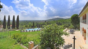 A villa with a pool, outdoor seating, and a view of the countryside. - Amazing Panoramic Villa La Poggiola (Arezzo)