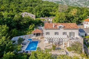 A villa with a swimming pool, surrounded by lush greenery and a mountainous backdrop. - Nature Villa Frangipane With Pool (Vinodol)