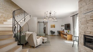Un salon moderne avec un escalier, une cheminée et un coin repas.